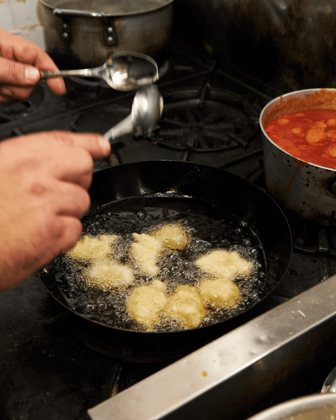Fritelle di baccala in a pan with hot oil